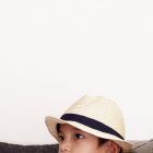 Portrait of serious boy wearing straw hat on white background — Stock Photo
