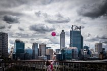 Girl throwing balloon into air — Stock Photo