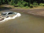 Graues Auto fährt bei Fahrt durch Fluss — Stockfoto