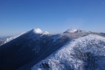 Schneebedeckte graue Berglandschaft und blauer Himmel — Stockfoto