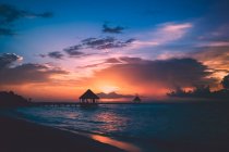 Beautiful sunset sky, sea water and small house on pier — Stock Photo