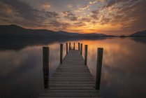 Belo céu por do sol e cais na água do lago — Fotografia de Stock