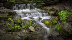 Flusslauf, lange Belichtung von Wasserfällen und Felsen mit Moos — Stockfoto