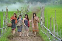 Азійка, одягнена в традиційну культуру тайців, йде додому на поле, в стилі вінтажу. — стокове фото
