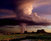 Una altísima célula de tormenta que se mueve a través de Monument Valley en la frontera de Utah y Arizona cerca de la puesta del sol, EE.UU. - foto de stock