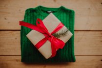 Caja de regalo con cinta roja sobre fondo de madera - foto de stock