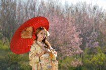 Японская девушка в традиционной одежде под названием Кимоно с цветком Сакуры — стоковое фото