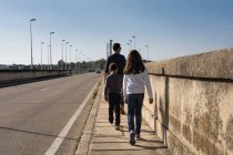 Père et deux enfants marchant dans la rue — Photo de stock