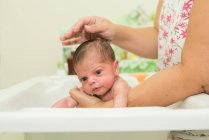 Woman bathing a newborn baby — Stock Photo