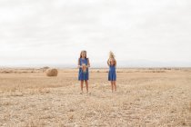Two girls standing in a field — Stock Photo
