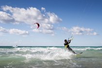L'uomo kitesurf sulle onde del mare — Foto stock