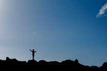 Silhouette d'un garçon debout sur des rochers — Photo de stock