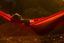 Жінка лежить в гамаку на сонці — стокове фото