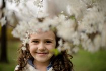 Retrato de uma menina em pé junto à árvore da flor de maçã — Fotografia de Stock