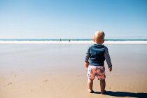 Мальчик стоит на пляже, Нуса Хэдс, Квинсленд, Австралия — стоковое фото