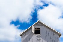 Ângulo baixo de uma casa sob céu nublado azul — Fotografia de Stock