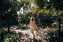 Chica joven caminando por arbusto de arena, Kingscliff, Nueva Gales del Sur, Australia - foto de stock