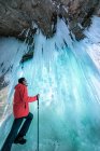 Uomo in piedi dietro una cascata ghiacciata, Matthiessen State Park, Illinois, America, USA — Foto stock