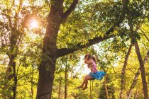 Girl swinging on a rope swing — Stock Photo
