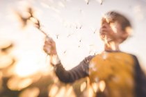 Blurred image of boy releasing seeds in the wind — Stock Photo