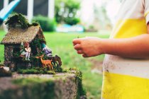Menina brincando com brinquedos de fadas jardim — Fotografia de Stock