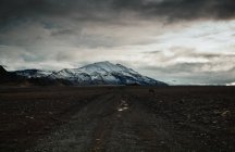 Мрачная дорога через зимний пейзаж, Исландия — стоковое фото