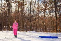 Девушка тащит сани по снегу — стоковое фото