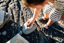 Девушка собирает камни на пляже — стоковое фото