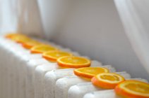 Vista da vicino di fette arancioni che si asciugano su un radiatore — Foto stock