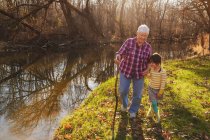 Grandmother walking by river with her granddaughter — Stock Photo