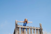 Mädchen steht auf einem Zaun — Stockfoto