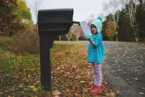 Дівчина збирає лист з поштової скриньки на вулиці — стокове фото