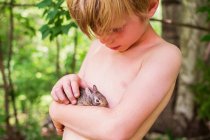 Entzückender kleiner Junge hält ein Kaninchen — Stockfoto