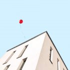 Живописный вид воздушного шара, летящего над зданием — стоковое фото