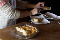 Женщина, подающая ломтики пирога с завтраком — стоковое фото