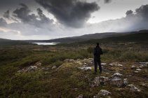 Vista posteriore dell'uomo in piedi nel paesaggio rurale, Islanda — Foto stock