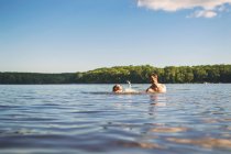 Father teaching his son to swim in a lake — Stock Photo