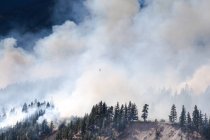 Vue panoramique d'un hélicoptère survolant un incendie de forêt à Lytton, Colombie-Britannique, Canada — Photo de stock