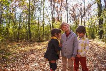 Drei glückliche Kinder spielen im Wald — Stockfoto