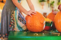 Girl scooping out pumpkin for Halloween — Stock Photo