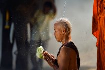 Ritratto di un monaco che versa acqua sulla testa di un altro monaco, Thailandia — Foto stock