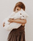 Menina abraçando seu gato de estimação com diferentes olhos coloridos — Fotografia de Stock
