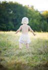 Menina de criança em chapéu de malha e shorts andando ao ar livre — Fotografia de Stock