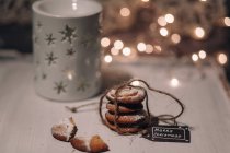 Christmas fairy lights and cookies on table in decorations — Stock Photo