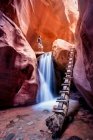 Woman standing above waterfall, red slot canyon, Utah, America, USA — Fotografia de Stock