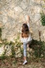 Girl climbing a wall in the garden — Stock Photo