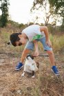 Boy playing with cat on nature — Stock Photo