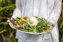 Mulher segurando uma salada de abobrinha de verão — Fotografia de Stock