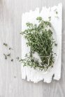 Bunch of thyme on a ceramic plate over wooden table — Stock Photo
