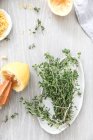 Zitronen und Thymian liegen auf Holztisch in Küche — Stockfoto